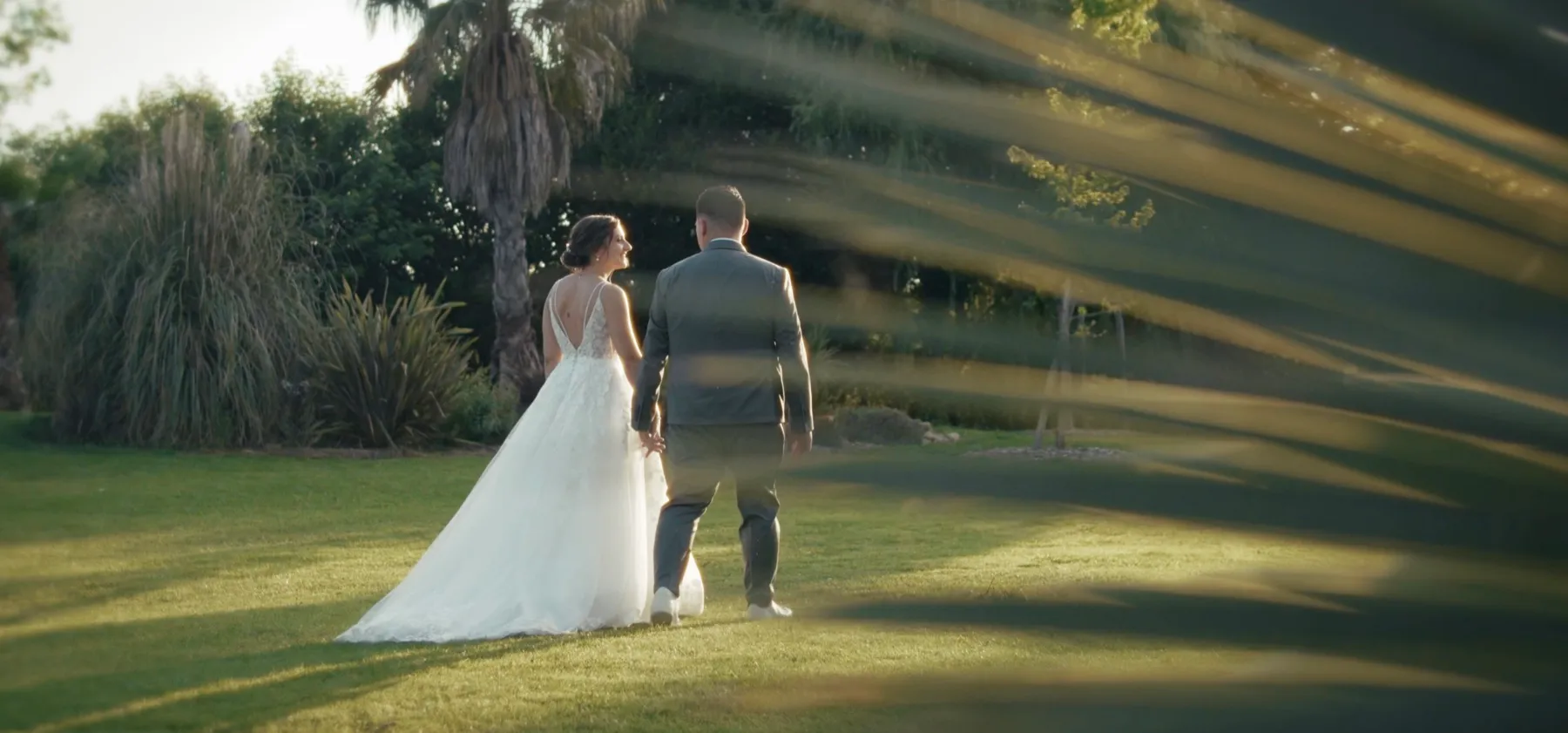 Les mariés marchent dans un jardin au soleil, filmés par Bastian Casaurang