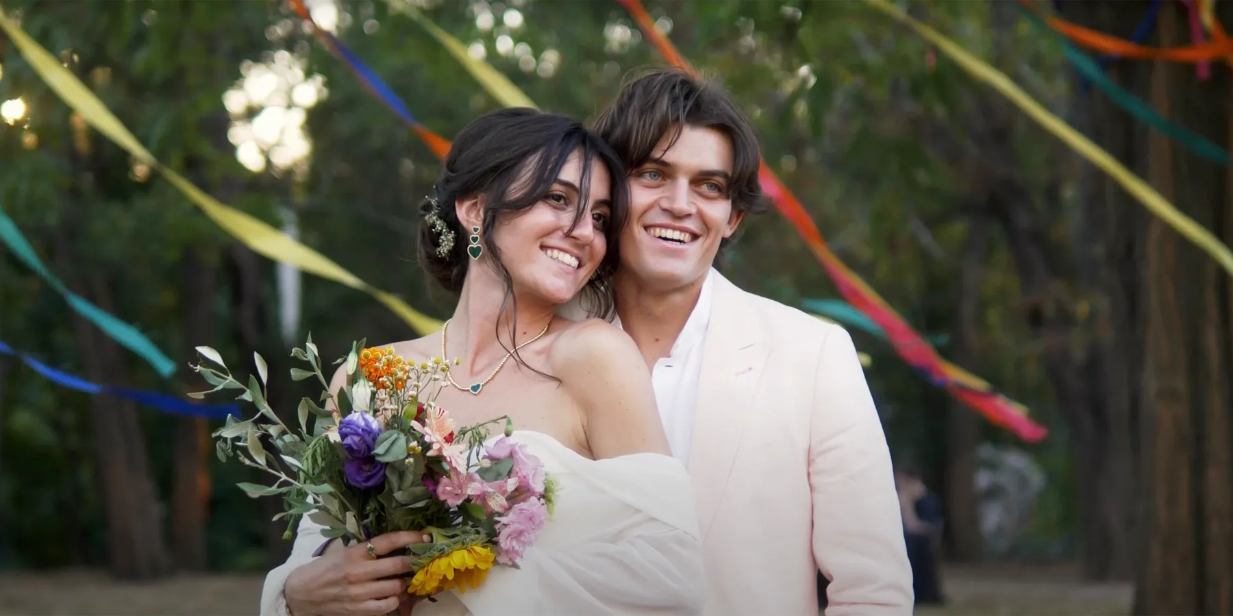 Mariés souriants sous des rubans colorés — film Bastian Casaurang